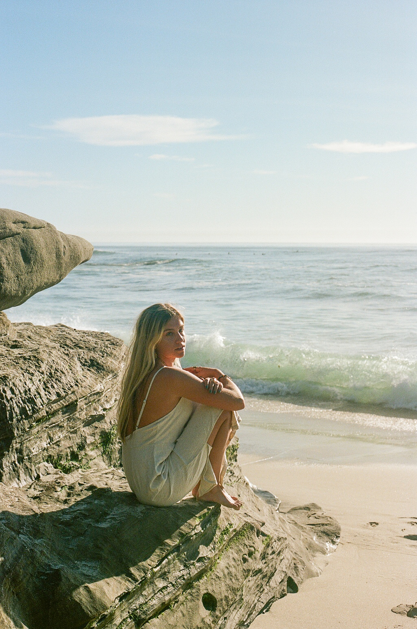 Woman Sitting on Rock Near Beach